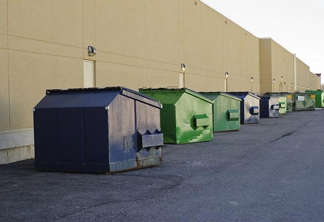 tilted front-load dumpsters being emptied by waste management workers in Cudahy, CA